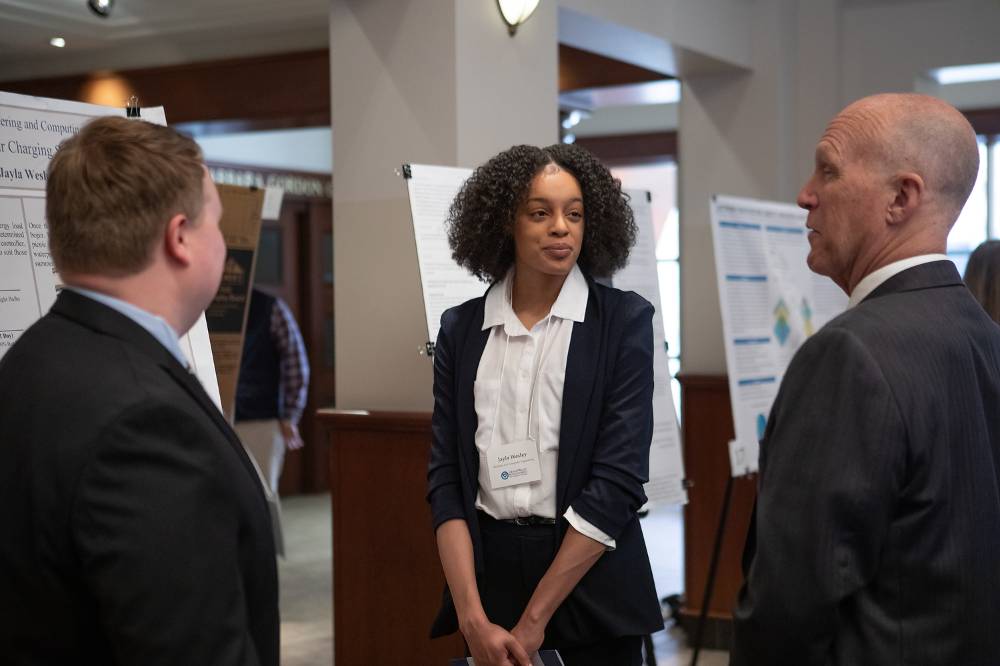 Matthew Burns (left) and Jayla Wesley (right), discussing their poster with Dr. Potteiger.